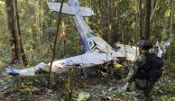 En esta foto proporcionada por la Oficina de Prensa de las Fuerzas Armadas de Colombia, un soldado permanece frente a los restos de una avioneta Cessna C206 el jueves 18 de mayo de 2023. La aeronave se estrelló en la selva de Solano, Colombia. Las autoridades buscaron a cuatro niños indígenas que piensan podrían haber sobrevivido el accidente.