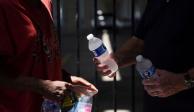 Un miembro de Star of Hope, una organización benéfica, reparte agua a personas sin hogar durante un período de clima cálido en Houston, Texas.