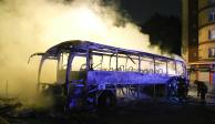 Bomberos arrojan agua a un autobús quemado, el sábado 1 de julio de 2023, en Nanterre, en las afueras de París, Francia.