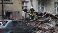 Un bombero ayuda a un ciudadano a recuperar sus pertenencias en un edificio bombardeado, ayer, en Sumi.