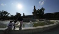 Unos turistas se refrescan en una fuente pública en el castillo Sforzesco en Milán, Italia, el sábado 15 de julio de 2023, en medio de la fuerte ola de calor que azota al sur de Europa.