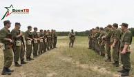 En esta foto tomada de un video difundido por el Ministerio de Defensa de Bielorrusia vía VoenTV el viernes 14 de julio de 2023, un instructor del contratista militar Wagner, centro, conversa con soldados bielorrusos durante un entrenamiento cerca de la aldea de Tsel, al sureste de Minsk, Bielorrusia.
