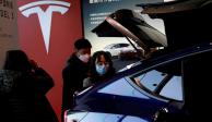 Visitantes con máscaras faciales revisan un vehículo utilitario deportivo (SUV) Tesla Model Y fabricado en China en la sala de exhibición del fabricante de vehículos eléctricos en Beijing, China, el 5 de enero de 2021