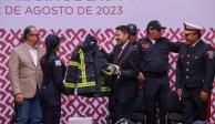 El Jefe de Gobierno, Martí Batres, entrega a una bombero su nuevo traje, ayer.