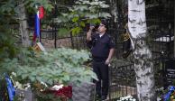 Un policía toma una foto a la rumba de Prigozhin, ayer, en un cementerio de San Peterburgo.