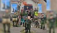 Foto de niños rusos vestidos de soldados con armas y haciendo la señal de victoria.