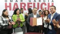 Omar García Harfuch presume la constancia de su solicitud de registro entregada ayer, rodeado por simpatizantes.