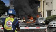 Autos arden después de que un cohete disparado desde la Franja de Gaza impactara en un estacionamiento y un edificio residencial en Ashkelon, sur de Israel