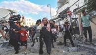 Familias palestinas salen corriendo de sus hogares después de los ataques aéreos israelíes, el martes.