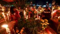 Pobladores de Santa María Atzompa, en Oaxaca, velan las tumbas de sus muertos.