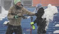 Seguidor de los Bills saca la nieve del estadio para el juego de hoy.