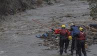 Rescatistas ayudan a un hombre de la tercera edad a salir de un arroyo en el que quedó atrapado, ayer.