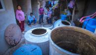 En el triángulo, Iztapalapa, una familia espera, con los tambos vacíos, la llegada de una pipa, ayer .