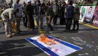 Manifestantes iraníes queman una bandera de Israel.