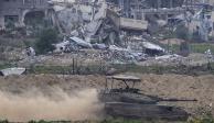 Un tanque de las Fuerzas de Defensa Israelí avanza frente a edificios destruidos en Gaza, ayer.