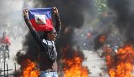 Una persona sostiene una bandera de Haití durante una protesta