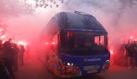 Aficionados del Barcelona queman bengalas mientras el autobús del equipo español llega al Estadio Olímpico de Montjuic para la vuelta de cuartos de final de Champions League.