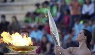 La actriz Mary Mina, como una sacerdotisa griega, sostiene una antorcha con la llama de los Juegos Olímpicos en el Estadio Panatenaico de Atenas