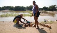 Indocumentados, en un campamento que adaptaron cerca del río Suchiate, ayer.