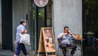 Un hombre habla por teléfono mientras espera en un café.