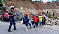 Rescatistas trabajaron en una unidad habitacional afectada por deslaves, ayer.