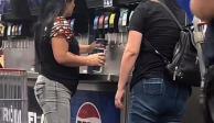 mujeres se llevan el refresco de una máquina del Costco.