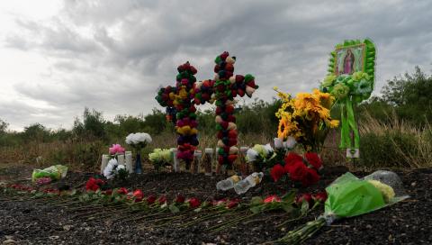 Flores, velas y botellas de agua se colocaron en la escena donde 52 migrantes fueron encontrados muertos dentro de un camión de remolque en San Antonio, Texas