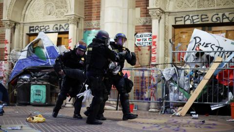 Policías desalojan a inconformes, ayer en la Universidad de California.