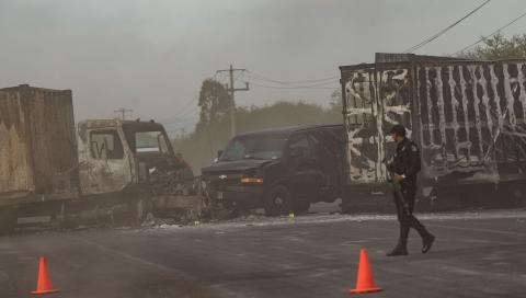 Policía de Zacatecas observan, ayer, los camiones que grupos criminales incendiaron en la madrugada.