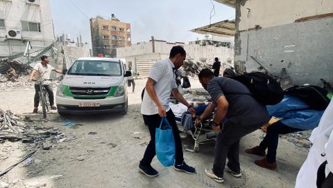 Voluntarios ayudan a evacuar a víctimas en un hospital en Gaza, ayer.