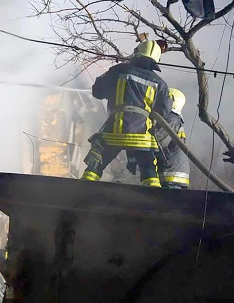 Bomberos sofocan las llamas en un edificio alcanzado por misiles rusos, ayer, en Odesa, Ucrania.