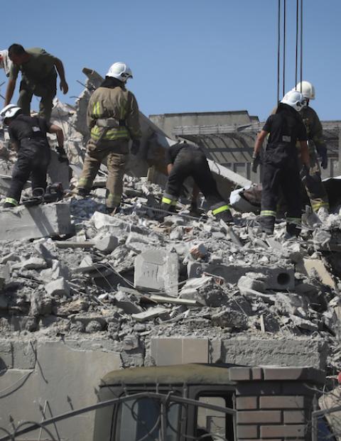 Bomberos ucranianos laboran en el edificio de departamentos que fue bombardeado en Odessa, ayer.