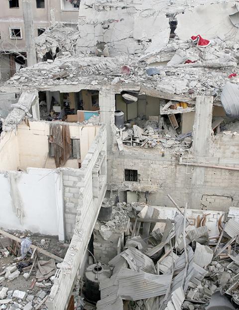 Ciudadanos gazatíes conviven en medio de casas y edificios destruidos por los ataques israelíes, ayer.