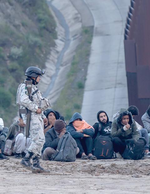 Migrantes detenidos junto al muro fronterizo en Tijuana, el pasado 1 de abril.