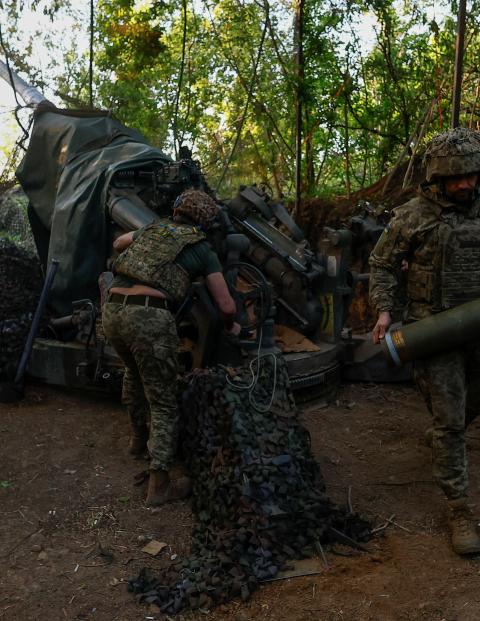 Tropas ucranianas disparan un arma contra soldados enemigos desde una trinchera, ayer.
