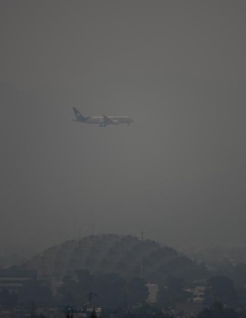 Un avión sobrevuela Ciudad de México, que presentó mala calidad de aire, ayer.