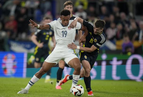 Dan Ndoye, de Suiza, y Kieran Tierney, de Escocia, disputan un balón en el duelo entre ambas selecciones en la Eurocopa 2024.