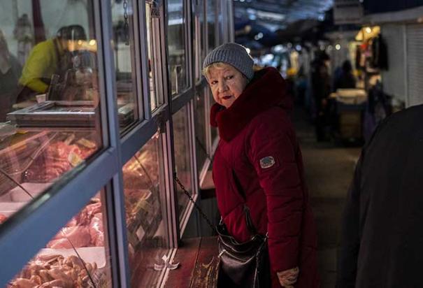 Una mujer compra carne en un mercado en Kiev, Ucrania, el jueves 1 de diciembre de 2022