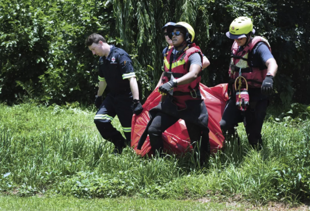 Rescatistas cargan el cadáver de una víctima de una inundación en el río Jukskei, en Johannesburgo, el domingo 4 de diciembre de 2022.