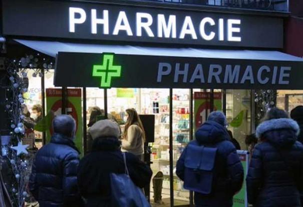 Personas esperan frente a una farmacia para hacerse una prueba de COVID-19 en París, Francia, el domingo 9 de enero de 2022