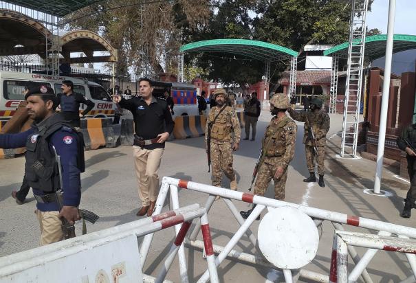 Soldados y policías despejan el acceso para ambulancias al lugar donde explotó una bomba, en una entrada a oficinas policiales en Peshawar, Pakistán, el lunes 30 de enero de 2023