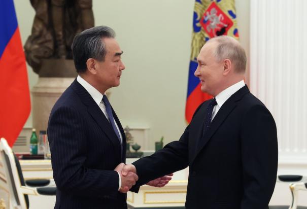 El ministro de Exteriores chino (izq.), Wang Yi, saluda al presidente de Rusia, Vladimir Putin, ayer.