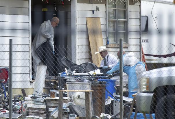 Policías sacan cadáveres de una casa en donde cinco personas fueron baleadas la noche previa el sábado 29 de abril de 2023 en Cleveland, Texas.