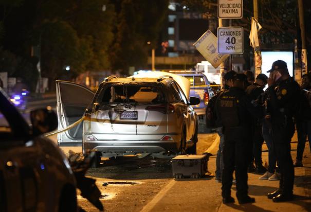 Policías resguardan Las inmediaciones de un centro de votación en Guatemala, luego de que un vehículo fuera atacado ayer.