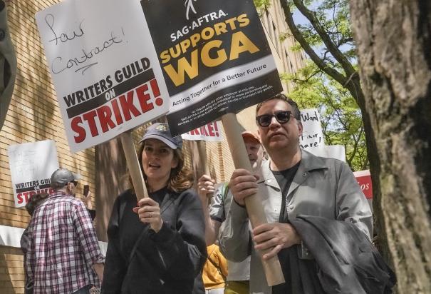 Los actores y comediantes Tina Fey, al centro, y Fred Armisen, a la derecha, se unen a miembros en huelga del Sindicato de Guionistas de Estados Unidos durante un mitin frente a Silvercup Studios, el martes 9 de mayo de 2023, en Nueva York. Los actores sindicalizados de Hollywood al borde de una huelga acordaron permitir una intervención de última hora de los mediadores federales, pero dicen que dudan que se llegue a un acuerdo antes de la fecha límite de negociación del miércoles 12 de julio de 2023.