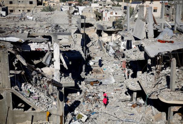 Niños palestinos caminan entre las ruinas, al sur de la Franja de Gaza, ayer.