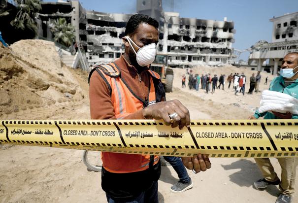 Voluntarios palestinos realizan labores en una presunta fosa común cerca de un hospital en Gaza.