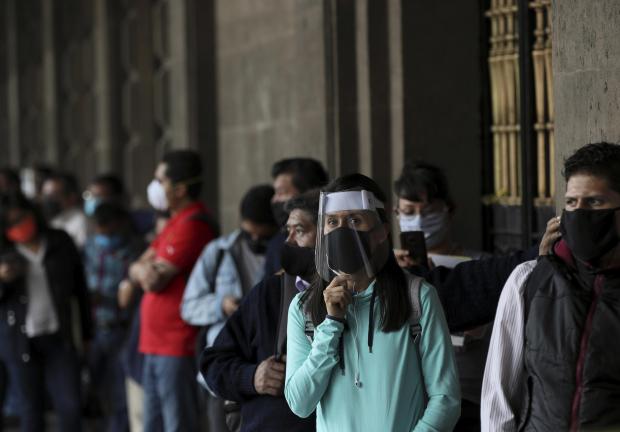 Personas portan cubrebocas y protectores a causa de la pandemia del nuevo coronavirus, en la Ciudad de México, el 1 de junio de 2020.