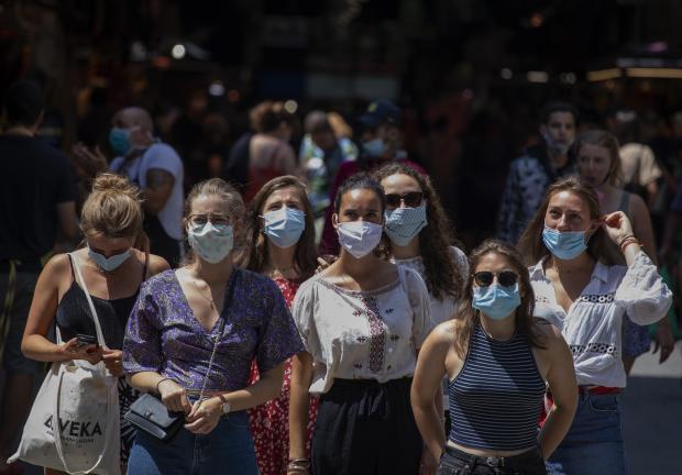 Turistas con mascarilla esperan para cruzar una calle en Barcelona, el 16 de julio de 2020.
