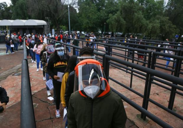 Jóvenes hacen fila para ingresar al Estadio Olímpico Universitario.